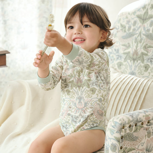 Baby wearing Bamboo Cotton Jersey Long Sleeve Kimono Onesie, sitting on sofa