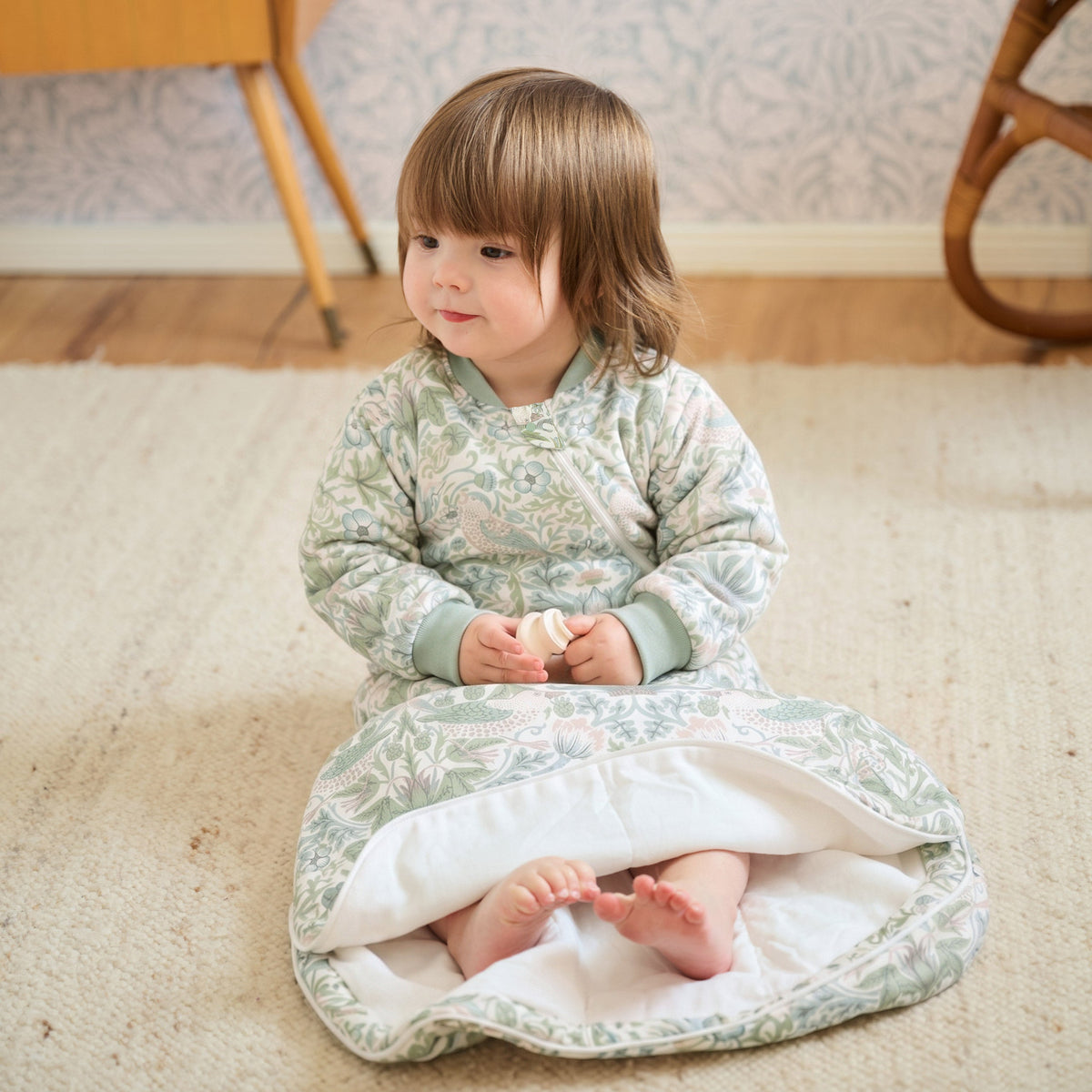 Baby wearing Strawberry Thief Slate Blue sleep bag, sitting