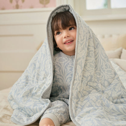 Child wearing Acorn Slate Blue cozy blanket over head, lifestyle
