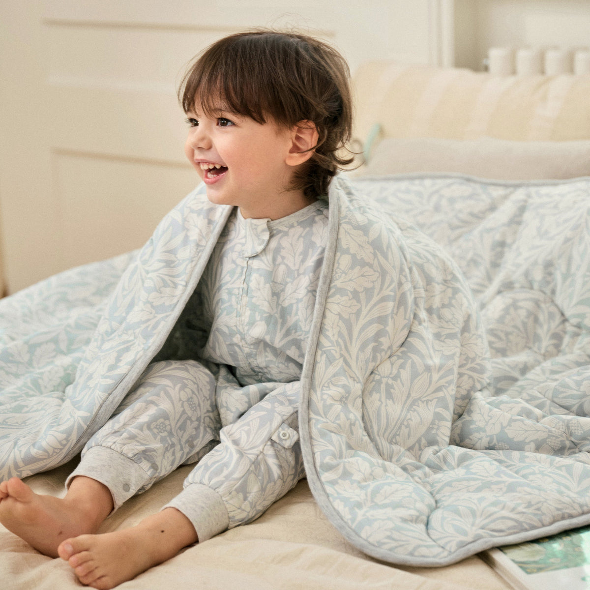 Baby feet wrapped in Acorn Slate Blue cozy blanket, lifestyle