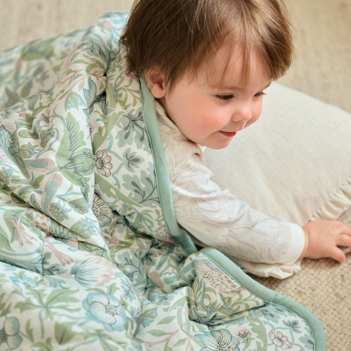 Toddler wrapped in Strawberry Thief Slate Blue cozy blanket, lifestyle
